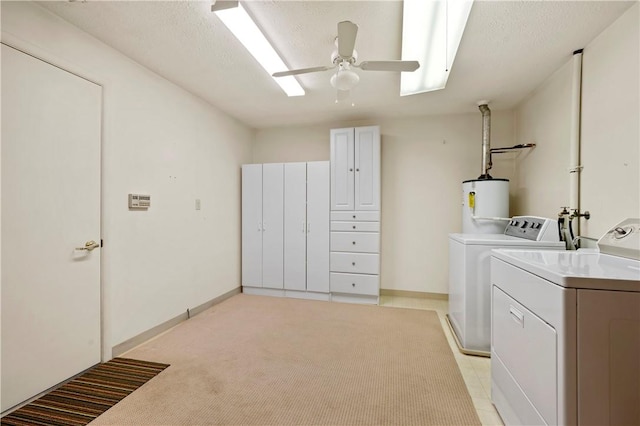 washroom with water heater, washer and clothes dryer, a textured ceiling, and a ceiling fan