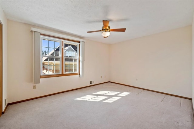 unfurnished room featuring light carpet, baseboards, and a textured ceiling