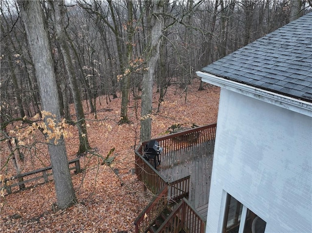 view of yard featuring stairs, a forest view, and a deck