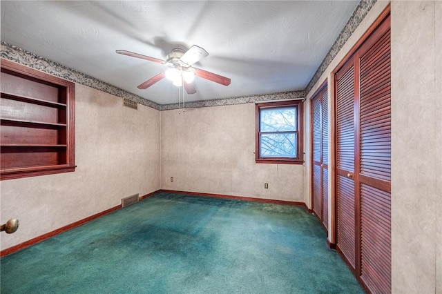 empty room with baseboards, visible vents, ceiling fan, and carpet flooring