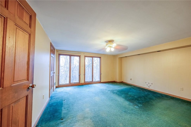 spare room featuring carpet floors, a ceiling fan, and baseboards