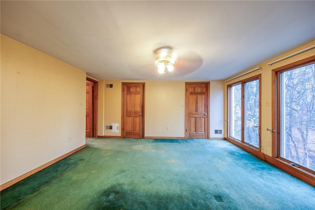 carpeted spare room featuring visible vents and baseboards