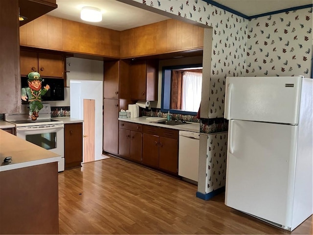 225 Country Club Rd, Penn Twp But, PA 16002 - kitchen featuring white appliances, a sink, wood finished floors, light countertops, and wallpapered walls
