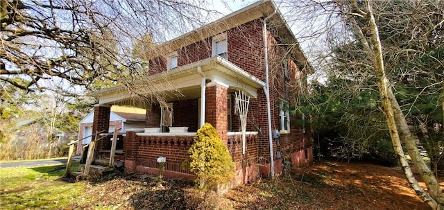 view of property exterior featuring a porch and brick siding