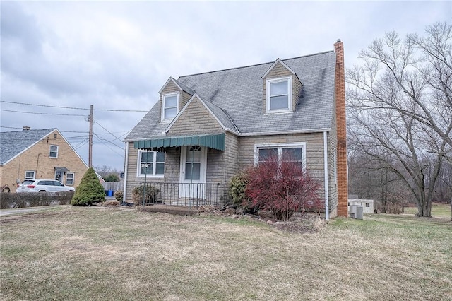 view of front of home featuring a chimney, covered porch, cooling unit, stone siding, and a front lawn