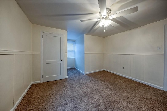 empty room featuring carpet, ceiling fan, and a decorative wall