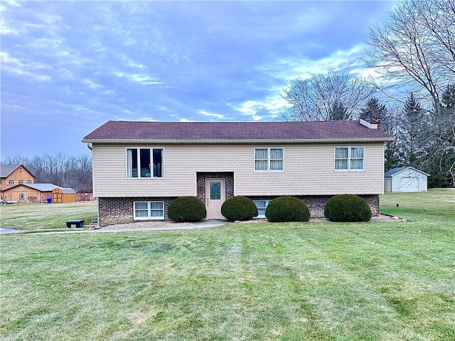 raised ranch with an outdoor structure, a chimney, a front lawn, and brick siding