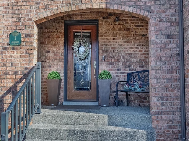 entrance to property featuring brick siding