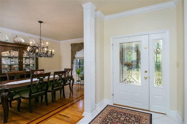 entryway with baseboards, crown molding, light wood finished floors, and decorative columns