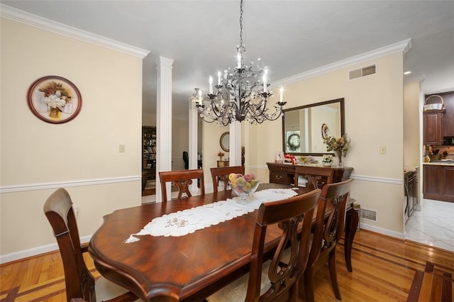 dining room with ornate columns, light wood-style flooring, visible vents, and crown molding