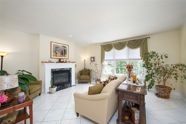 living room with light tile patterned floors, a premium fireplace, and baseboards