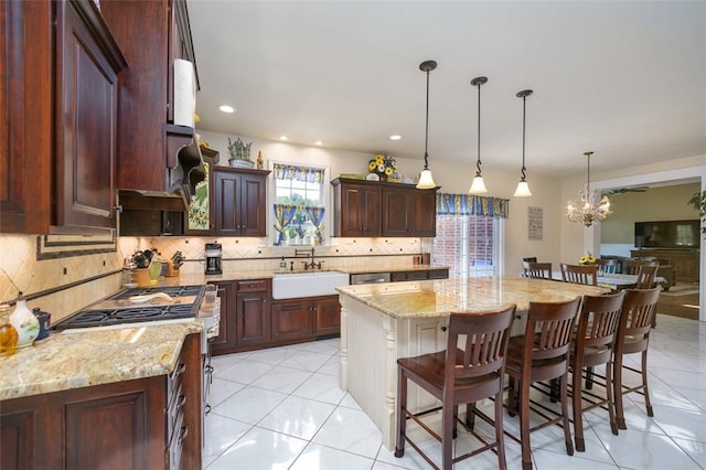 kitchen featuring a kitchen island, a sink, backsplash, and a kitchen bar