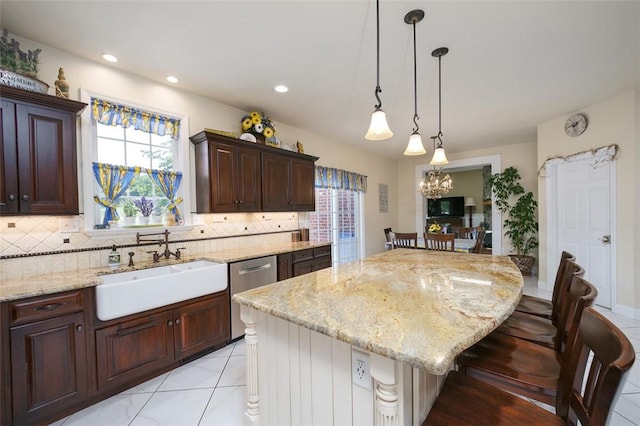 kitchen with a kitchen island, backsplash, a kitchen breakfast bar, stainless steel dishwasher, and a sink