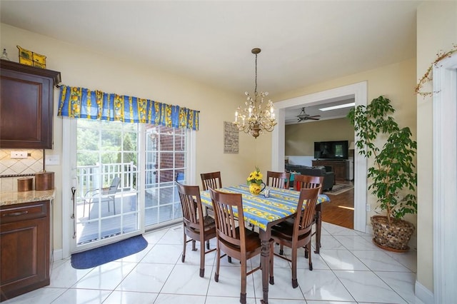 dining area featuring ceiling fan with notable chandelier and light tile patterned flooring