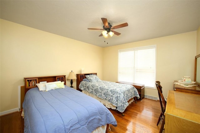 bedroom featuring ceiling fan, baseboards, and wood finished floors