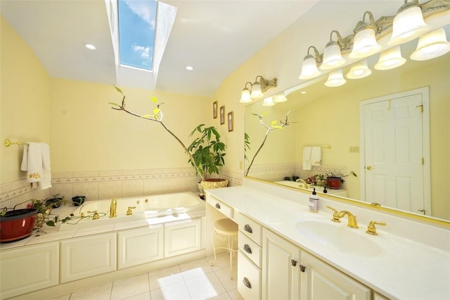 full bathroom featuring a skylight, tile patterned flooring, a garden tub, and vanity