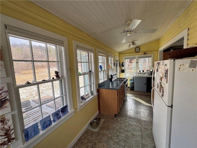 kitchen featuring lofted ceiling, dark countertops, a ceiling fan, freestanding refrigerator, and wooden ceiling