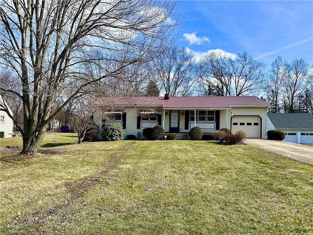 ranch-style house featuring a chimney, an attached garage, a front yard, metal roof, and driveway