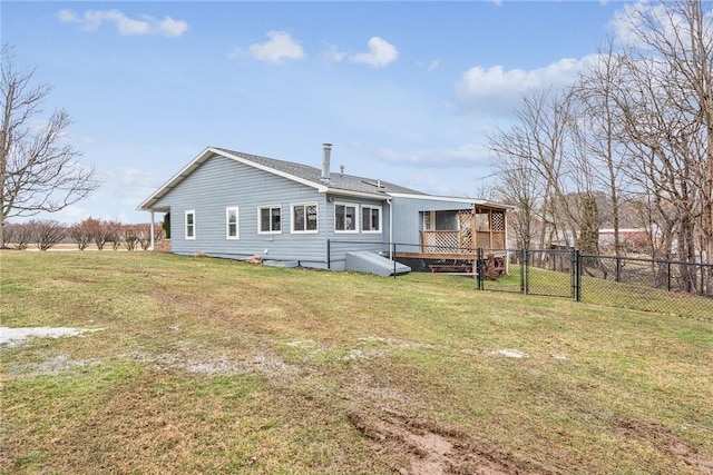 back of property featuring a gate, fence, and a lawn