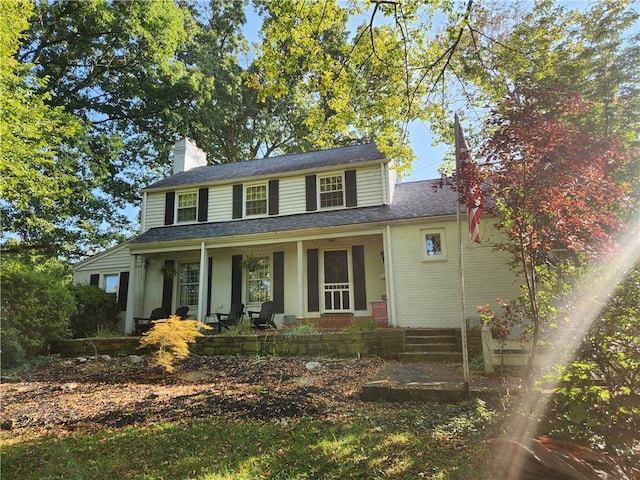 view of front of home featuring a porch and a chimney