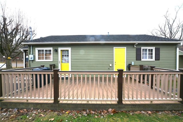 back of property featuring roof with shingles and a wooden deck