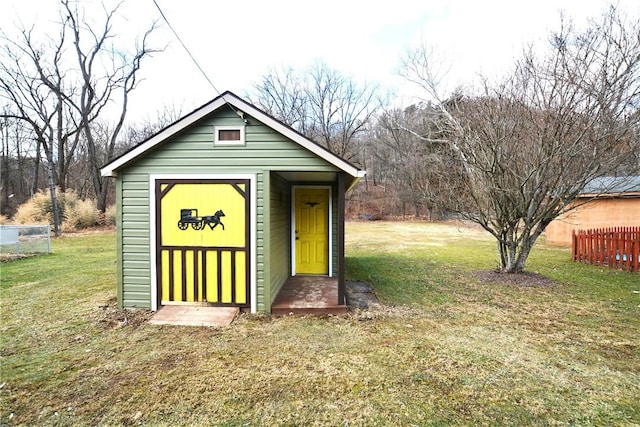 view of outbuilding featuring fence and an outdoor structure