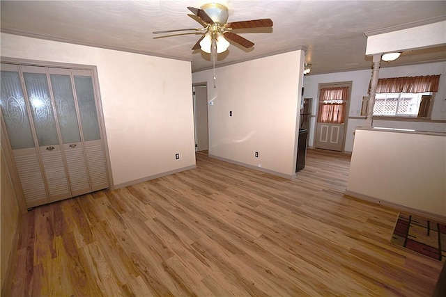 unfurnished bedroom featuring light wood-style flooring, baseboards, and a ceiling fan