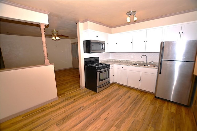 kitchen featuring stainless steel appliances, white cabinetry, a sink, and light wood finished floors