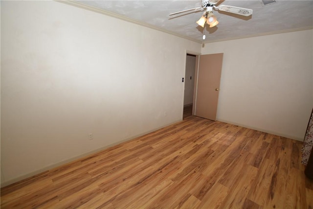 unfurnished room with ornamental molding, light wood-type flooring, visible vents, and a ceiling fan