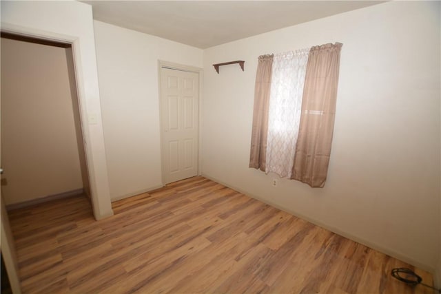 unfurnished bedroom with light wood-style flooring and a closet