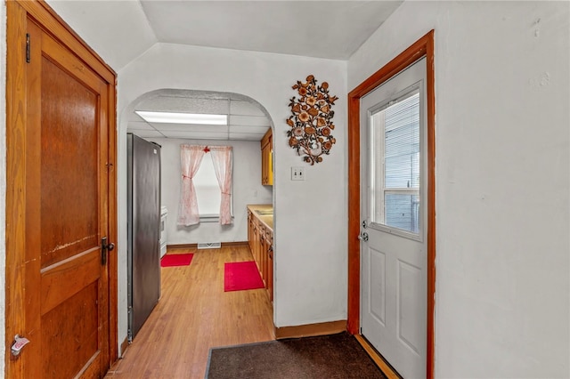 interior space with light wood finished floors, plenty of natural light, baseboards, and a drop ceiling