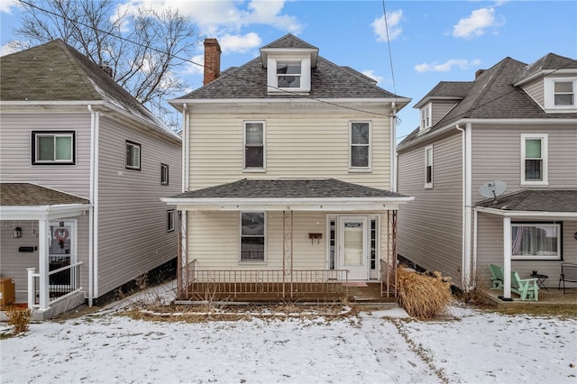 traditional style home with a porch, a chimney, and a shingled roof