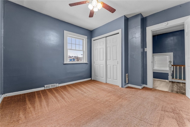 unfurnished bedroom featuring a closet, carpet flooring, visible vents, and baseboards