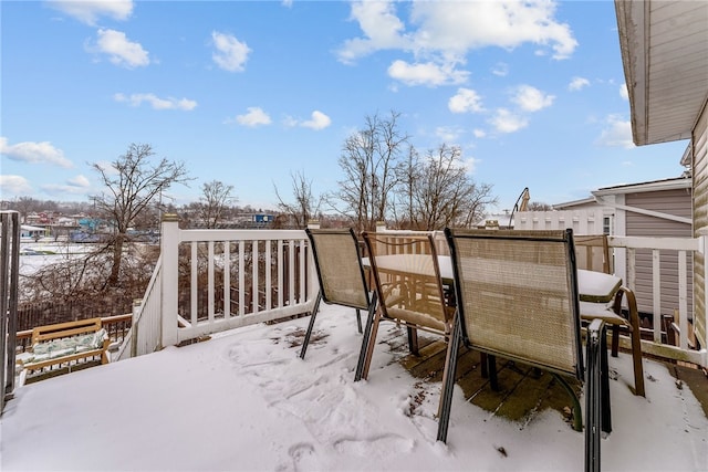 snow covered deck featuring outdoor dining space