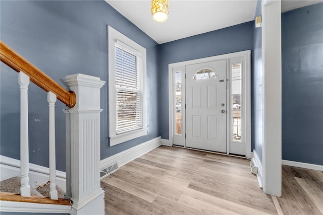 entrance foyer featuring light wood-type flooring, baseboards, visible vents, and stairway