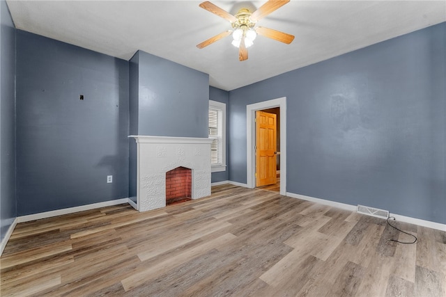 unfurnished living room featuring visible vents, baseboards, a tile fireplace, ceiling fan, and wood finished floors