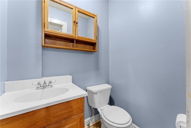 bathroom featuring vanity, toilet, and baseboards