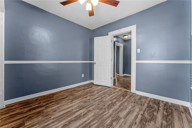 empty room with a ceiling fan, baseboards, and wood finished floors