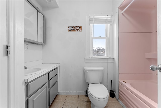 bathroom featuring tile patterned flooring, toilet, vanity, baseboards, and tub / shower combination