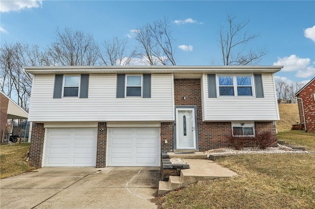 raised ranch featuring a garage, a front yard, brick siding, and driveway