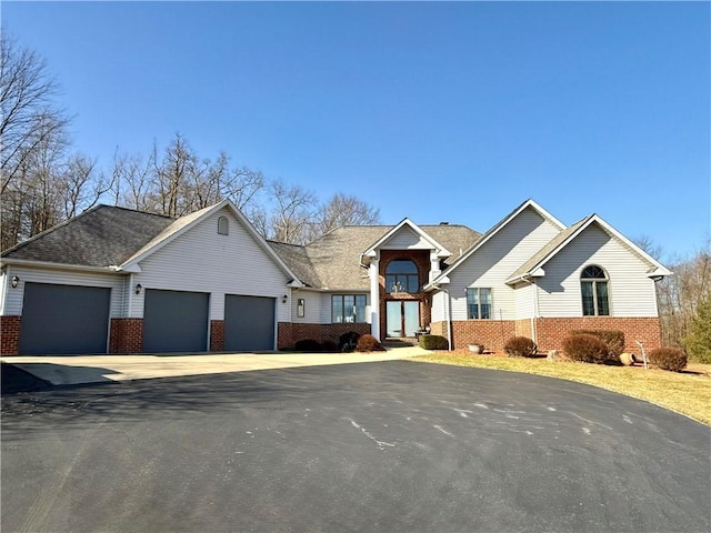 view of front facade featuring a garage, driveway, and brick siding