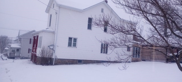 snow covered property featuring entry steps