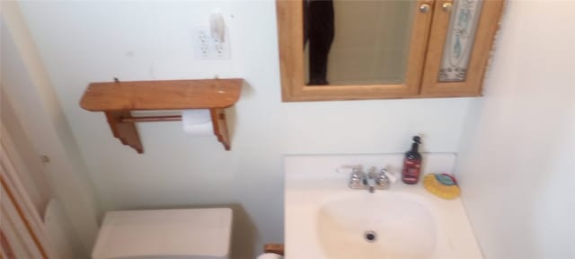 half bathroom with vanity and toilet