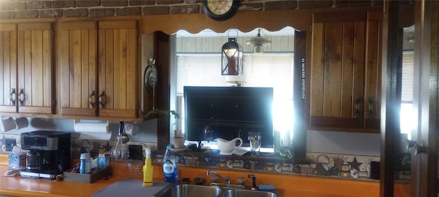 kitchen featuring brown cabinetry and a sink