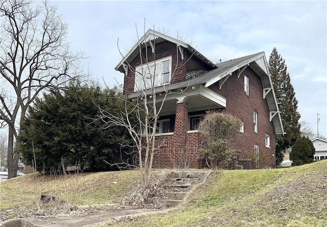 view of property exterior with brick siding and a lawn