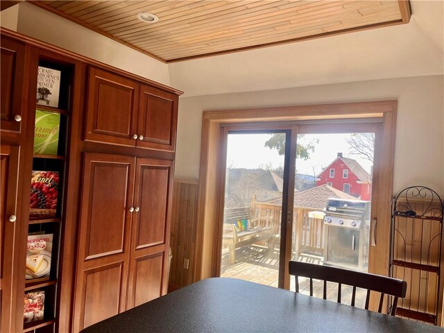 dining area with wainscoting, a healthy amount of sunlight, and wood ceiling