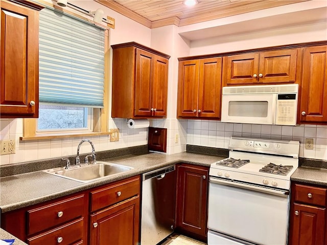 kitchen with crown molding, dark countertops, white appliances, tasteful backsplash, and a sink