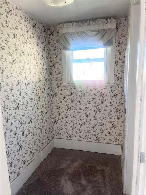 carpeted spare room featuring wallpapered walls and baseboards