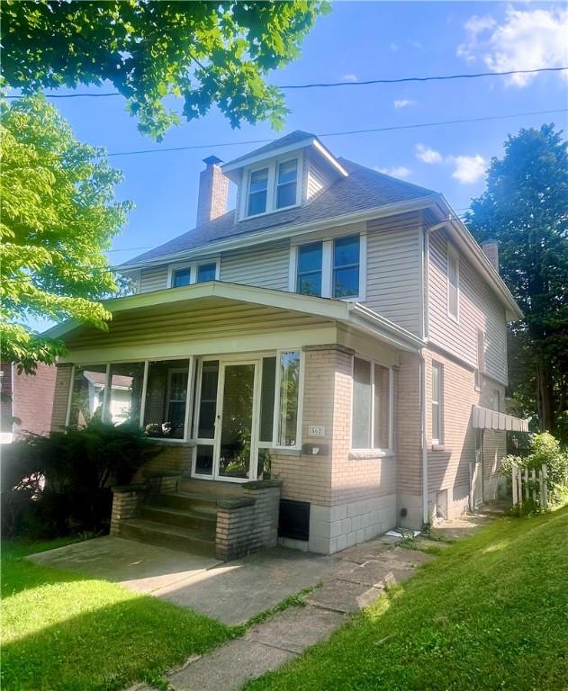 562 5th St, City Of But Ne, PA 16001 - american foursquare style home featuring a chimney, brick siding, and a front lawn