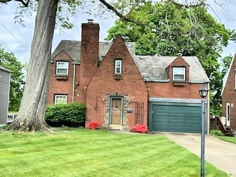 view of front of house with a front yard, a chimney, concrete driveway, and brick siding